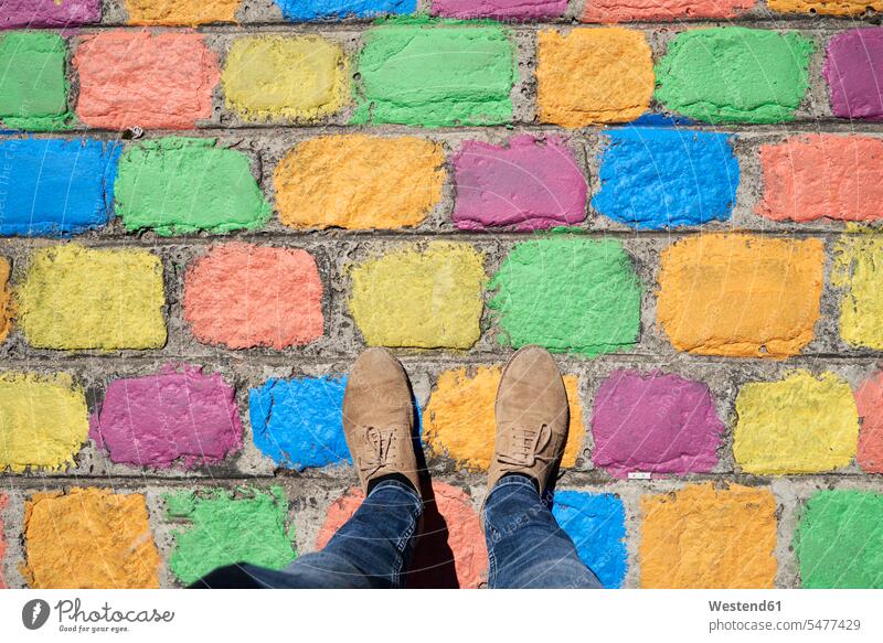 Argentina, Buenos Aires, La Boca, point of view shot of man standing on colorful pavement tile tiles man's shoe man's shoes multicolored multicoloured