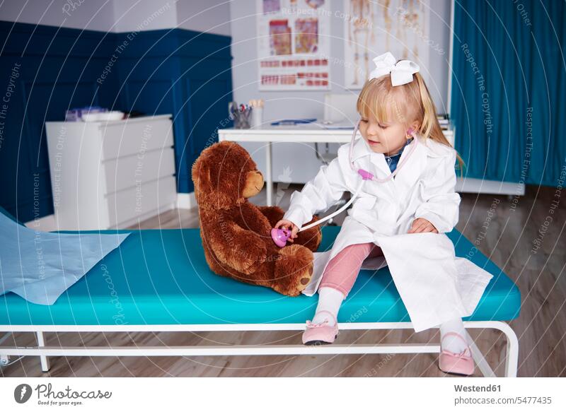 Girl with stethoscope examining teddy in medical practice teddies checking examine medical practices Doctors Office Doctor's Office girl females girls
