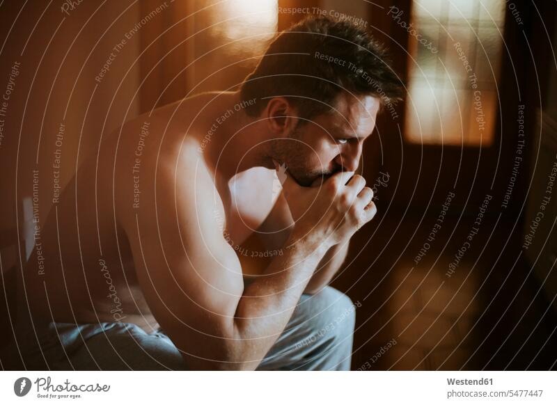 Close-up of shirtless thoughtful man sitting at home color image colour image Spain leisure activity leisure activities free time leisure time indoors