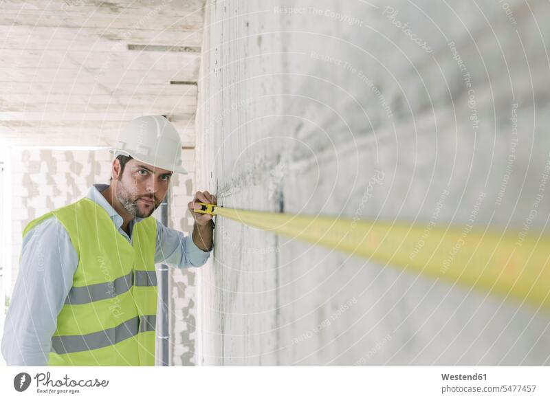 Architect metering a wall at construction site Occupation Work job jobs profession professional occupation architects work cloth work clothes workwear
