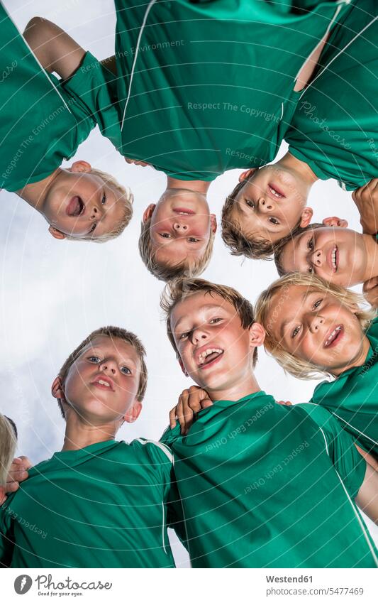 Happy young football players huddling soccer boy boys males huddle happiness happy footballers soccer players sport sports child children kid kids people