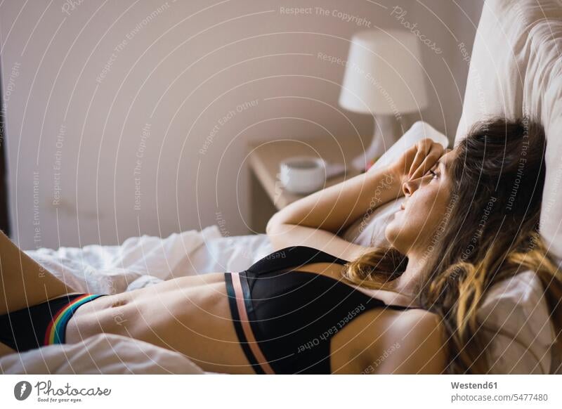 Daydreaming young woman in underwear lying on bed beds laying down lie lying down daydreaming dreamy females women day dreaming Daydreams Day Dream Adults