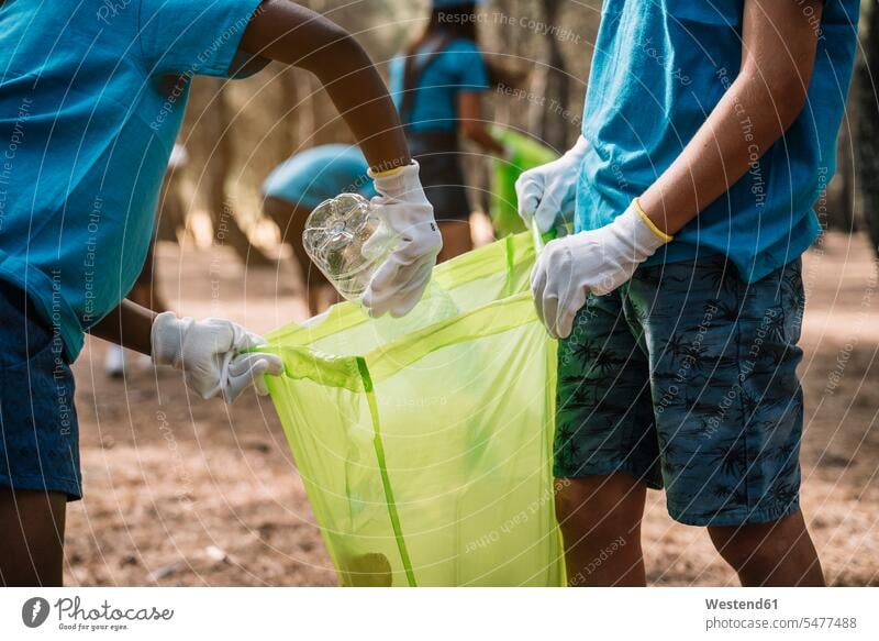 Close-up of volunteering children collecting garbage in a park human human being human beings humans person persons caucasian appearance caucasian ethnicity