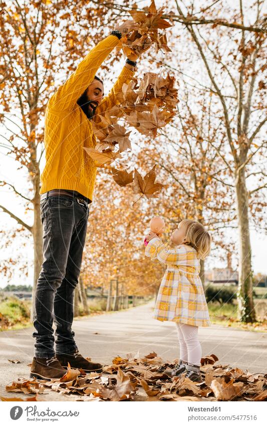 Father and daughter enjoying a morning day in the park in autumn, throwing autumn leaves joyful lust for life Leaf Leaves father fathers daddy dads papa Joy