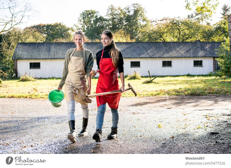 Two women working on a farm woman females confidence confident At Work Adults grown-ups grownups adult people persons human being humans human beings