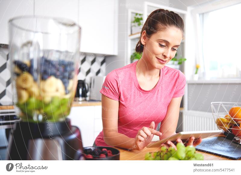Portrait of smiling young woman using tablet in the kitchen females women smile digitizer Tablet Computer Tablet PC Tablet Computers iPad Digital Tablet