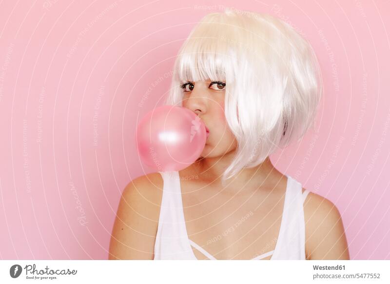 Portrait of young woman with pink gum bubble in front of pink background colour colours Rosy Distinct individual stylish Lifestyle look looks Alimentation food