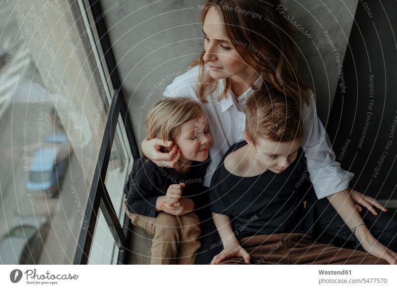 High angle view of woman sitting with sons by window at home color image colour image indoors indoor shot indoor shots interior interior view Interiors