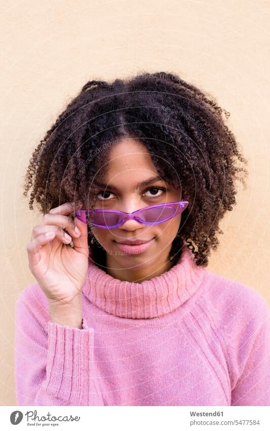 Portrait of young woman wearing pink turtleneck pullover and purple sunglasses portrait portraits sweater jumper Sweaters Rosy sun glasses Pair Of Sunglasses