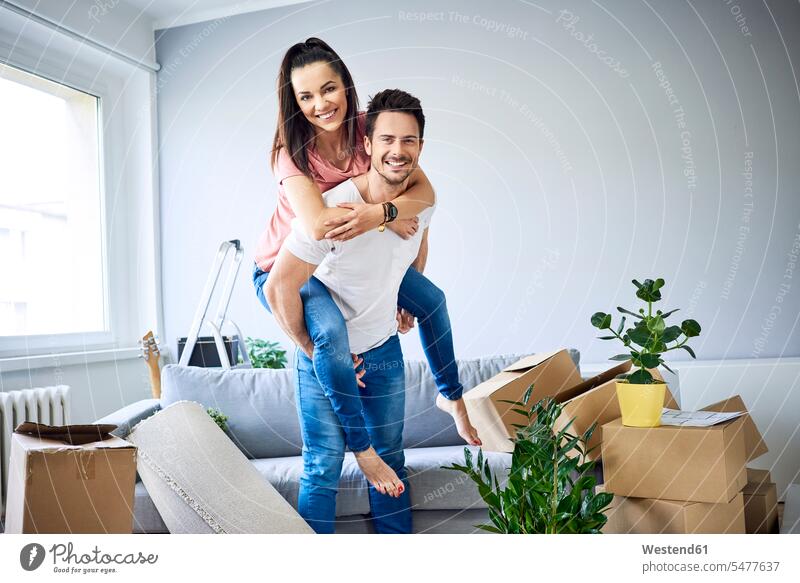 Portrait of cheerful couple moving in move in happiness happy twosomes partnership couples cardboard box cardboard boxes packing case packing cases portrait