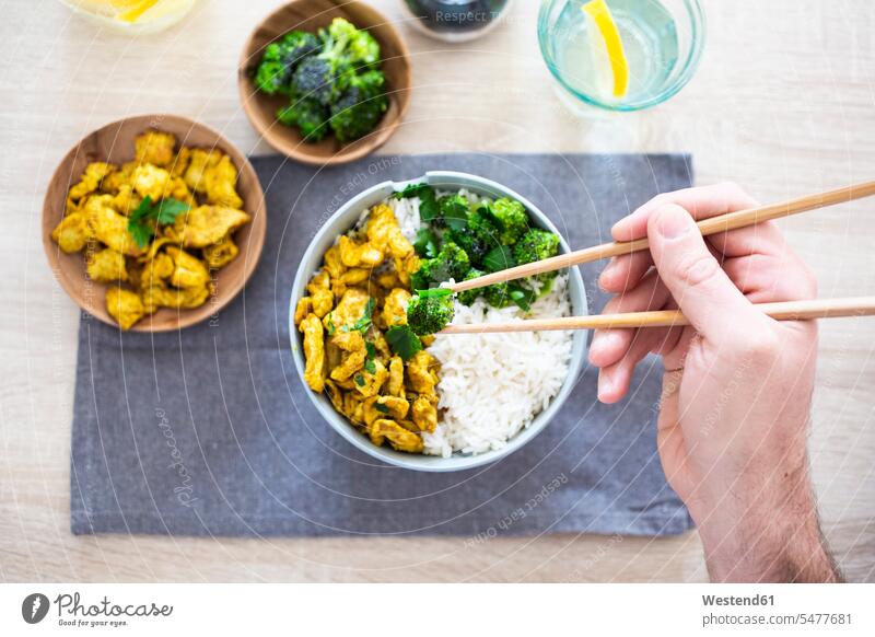 Curry chicken, broccoli and rice, man holding chopsticks with broccoli eating Chicken Curry Rice men males Food foods food and drink Nutrition Alimentation