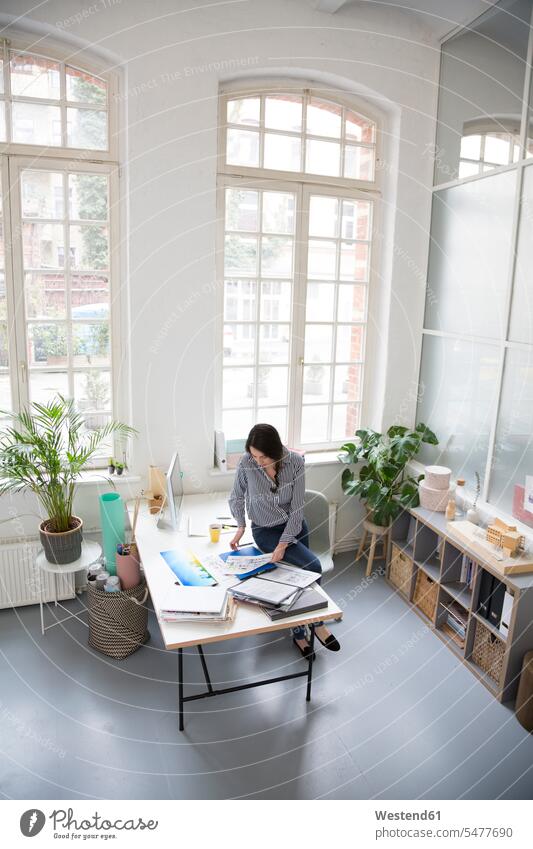 Woman working at desk in a loft office At Work offices office room office rooms lofts woman females women desks workplace work place place of work Adults
