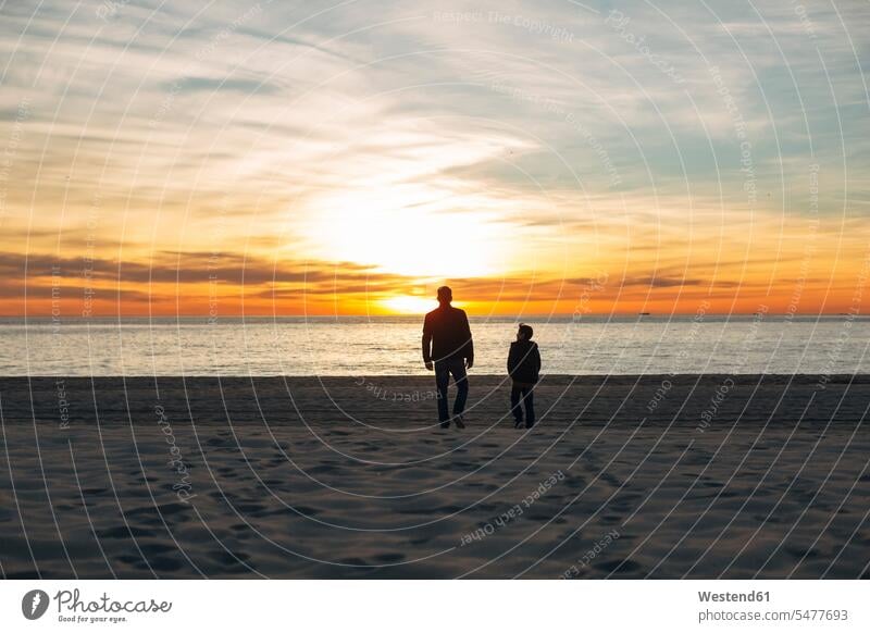 Father and son walking on the beach at sunset beaches going sunsets sundown sons manchild manchildren father pa fathers daddy dads papa atmosphere atmospheric
