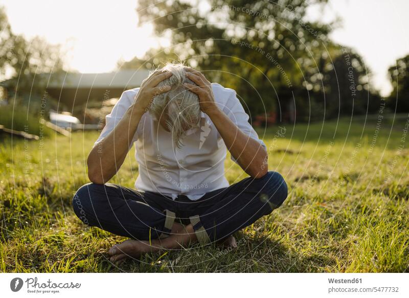 Man with head in hands sitting in backyard color image colour image full length full-length full body full-body full shot outdoors location shots outdoor shot