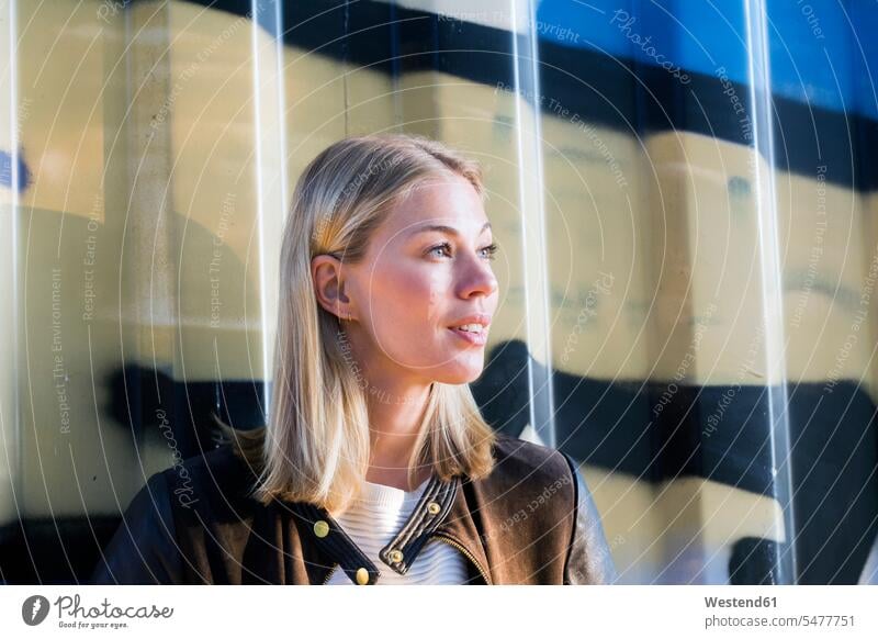 Portrait of blond woman in front of container looking at distance females women portrait portraits view seeing viewing blond hair blonde hair Adults grown-ups