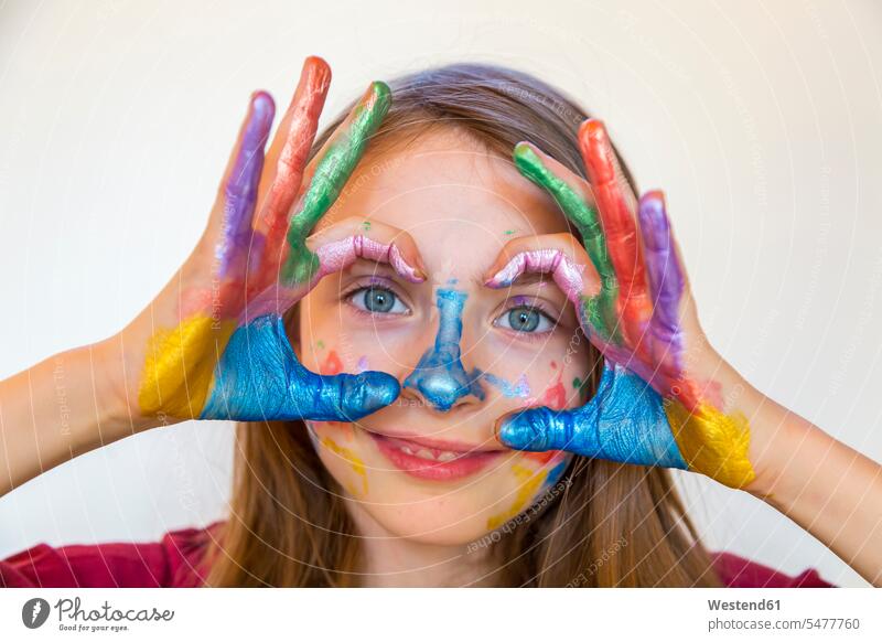 Portrait of smiling girl with finger paints on hands portrait portraits human hand human hands fingerpainting leisure free time leisure time Fun having fun