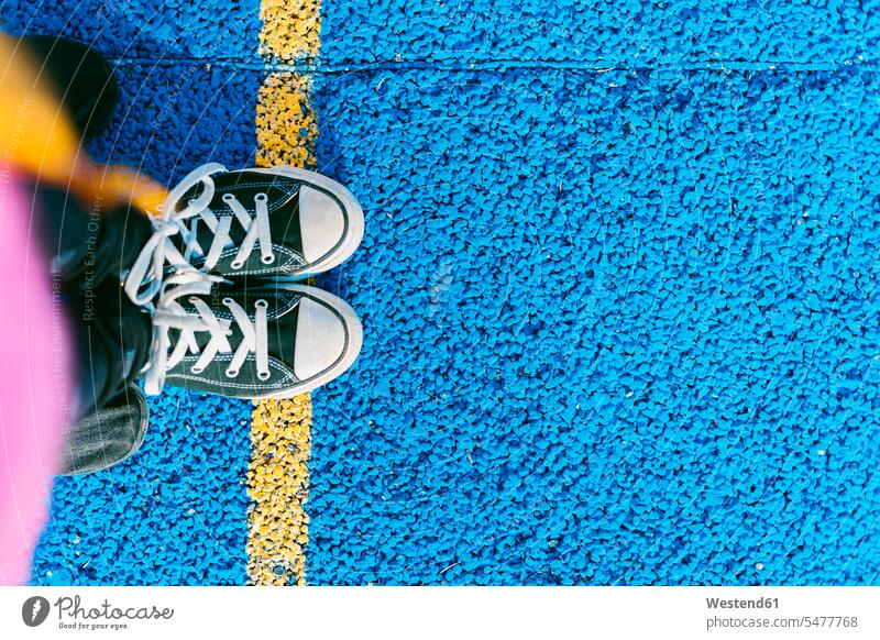 Girl standing on yellow line on blue sports court color image colour image 6-7 years 6 to 7 years children kid kids people human being human beings humans