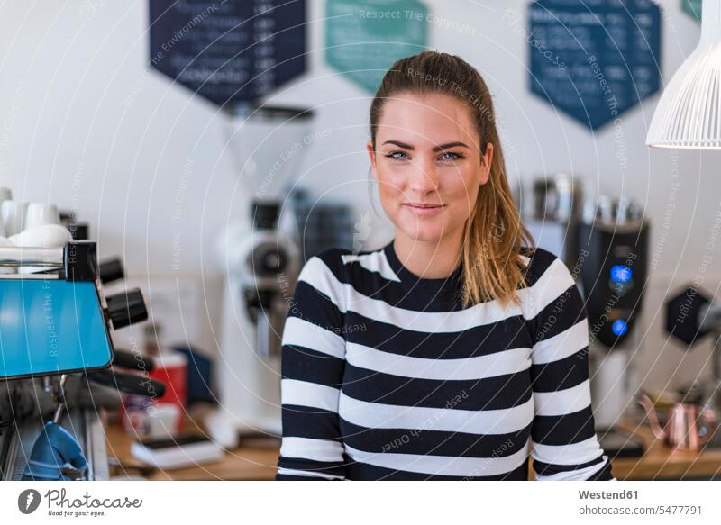 Portrait of smiling young woman in a cafe females women smile portrait portraits Adults grown-ups grownups adult people persons human being humans human beings