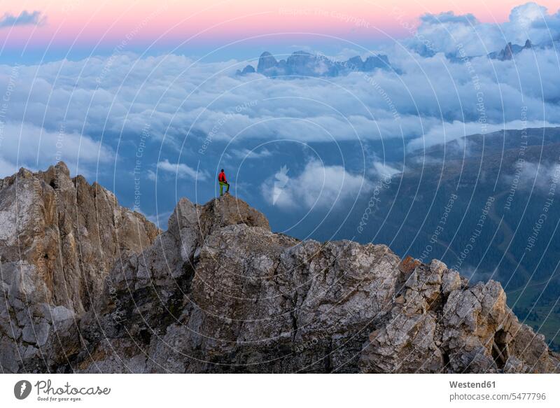 Italy, Veneto, Dolomites, Alta Via Bepi Zac, mountaineer standing on Pale di San Martino mountain at sunset the Veneto distant long distance Looking At View