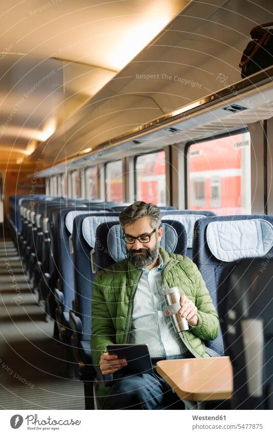 Man sitting in train using tablet Occupation Work job jobs profession professional occupation business life business world business person businesspeople