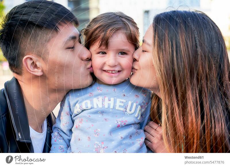 Happy parents kissing little girl human human being human beings humans person persons Asian Asians Chinese caucasian appearance caucasian ethnicity european