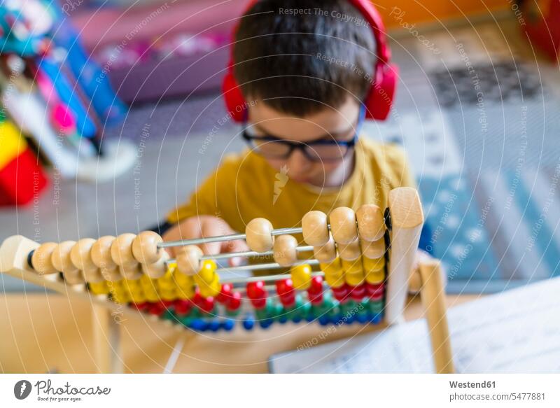 Boy calculating with abacus while sitting at home color image colour image indoors indoor shot indoor shots interior interior view Interiors Home Interior