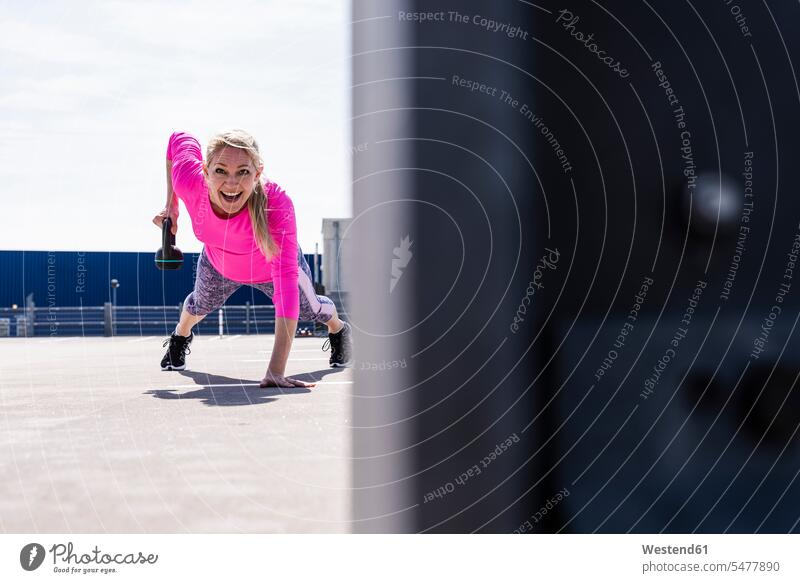 Woman training with dumbells, doing one-armed plank athlete Sportspeople Sportsman Sportsperson athletes Sportsmen exercising exercise practising Strength