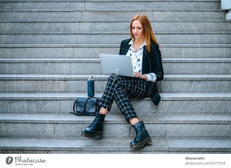 Young businesswoman sitting on stairs using laptop human human being human beings humans person persons caucasian appearance caucasian ethnicity european 1