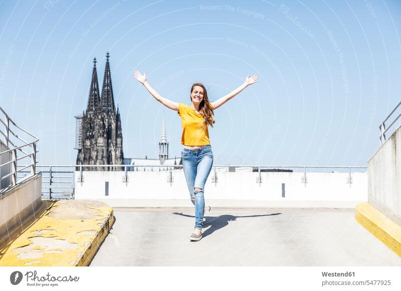 Germany, Cologne, happy woman on ramp of parking level with Cologne Cathedral in the background females women happiness Ramp Adults grown-ups grownups adult