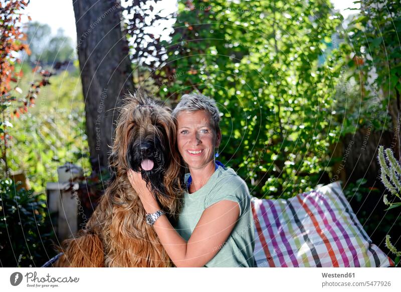Portrait of smiling woman head to head with her dog in the garden dogs Canine gardens domestic garden portrait portraits females women smile pets animal