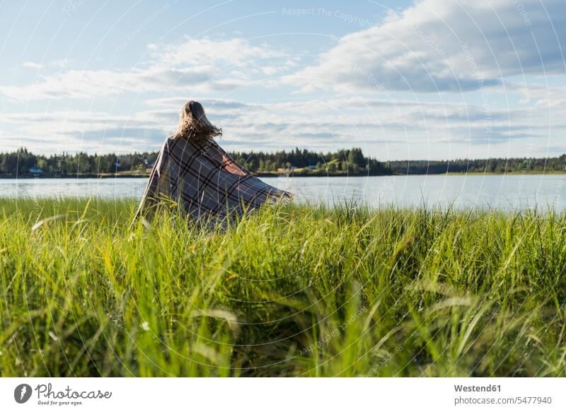 Finland, Lapland, woman wrapped in a blanket at the lakeside females women Blanket Blankets Lakeshore Lake Shore Wrapped Up Adults grown-ups grownups adult