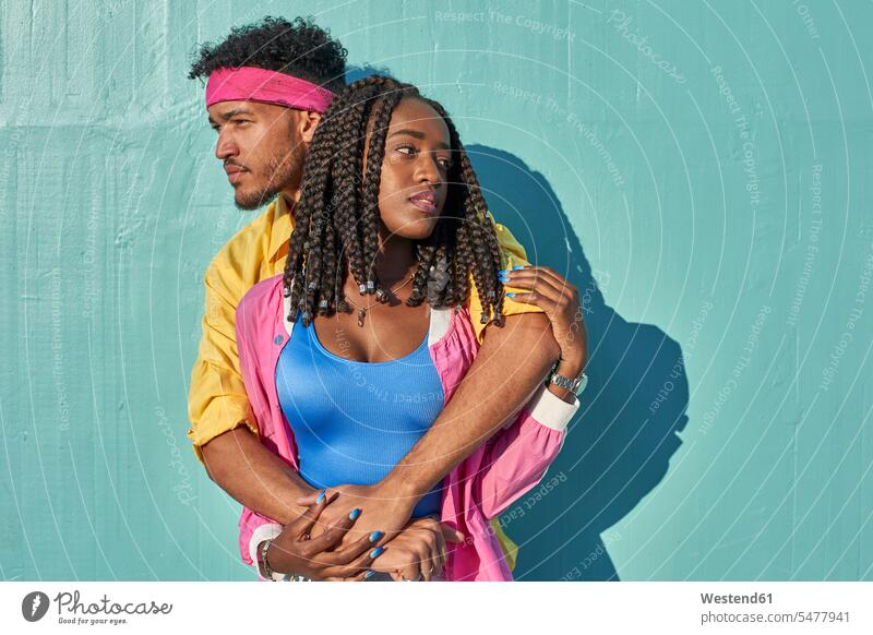 Young black lovers posing in front of a blue wall lyrical Romance human human being human beings humans person persons African black ethnicity coloured