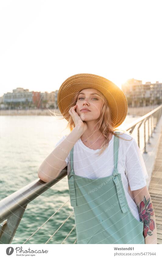 Young woman spending a day at the seaside, standing on bridge free time leisure time Distinct individual stylish Lifestyle beaches Athmospheric Mood atmospheric