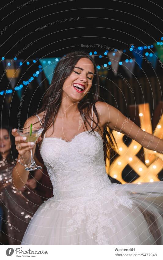 Happy bride laughing and dancing while holding cocktail on an outdoor night party Fun having fun funny brides Laughter Party Parties Cocktail Cocktails