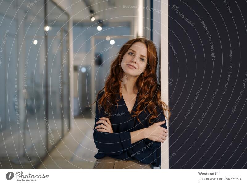 Portrait of smiling redheaded woman on office floor Occupation Work job jobs profession professional occupation business life business world business person