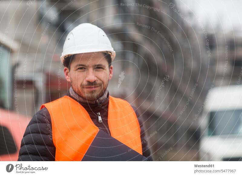 Portrait of content man wearing safety vest and helmet at construction site portrait portraits safety jacket Safety Helmet protective helmet Building Site sites