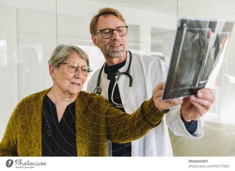 Doctor discussing x-ray image with senior patient health healthcare Healthcare And Medicines medical medicine disease diseases ill illnesses sick Sickness