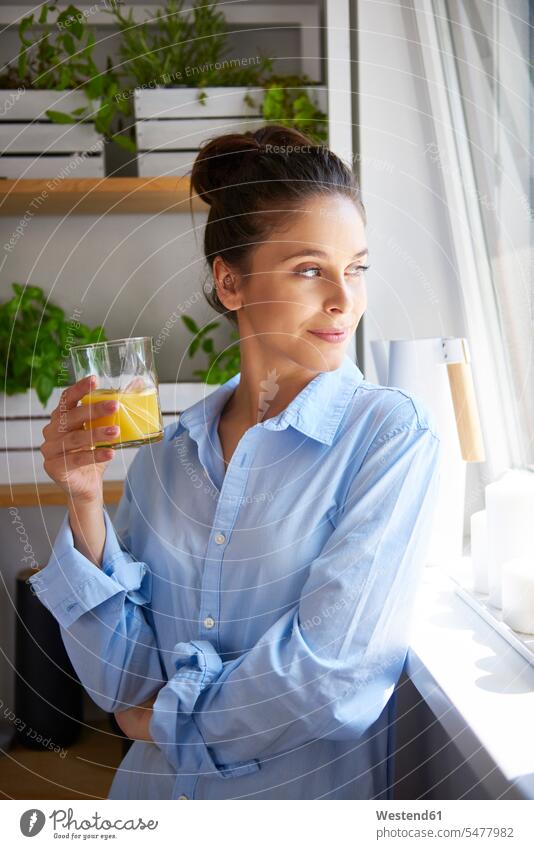 Young woman drinking orange juice in her kitchen Glass Drinking Glasses Freshness fresh optimistic optimism daydreaming day dreaming Daydreams Day Dream