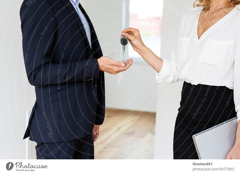 Close-up of real estate agent handing over key to client in new home human human being human beings humans person persons caucasian appearance