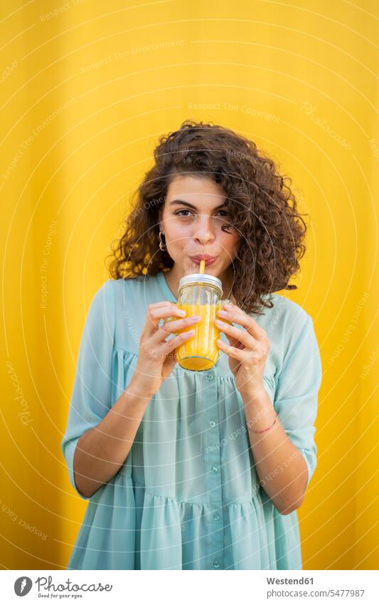 Portrait of woman drinking juice, yellow background human human being human beings humans person persons 1 one person only only one person caucasian appearance
