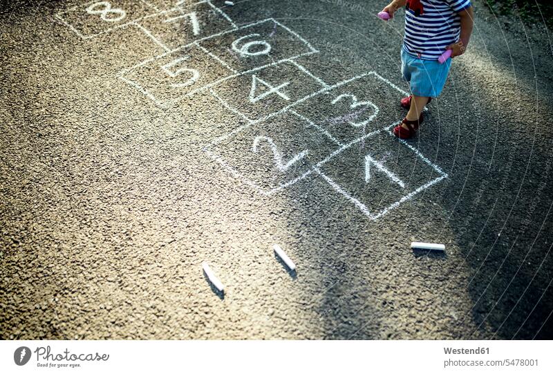 Little girl with drawn hopscotch on the street, partial view baby girls female road streets roads Hopscotch babies infants people persons human being humans