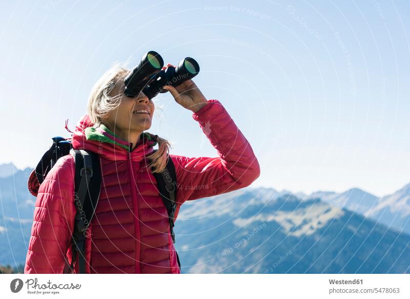 Austria, Tyrol, woman looking through binoculars during hiking trip view seeing viewing hiking tour walking tour females women hike excursion Getaway Trip Tours