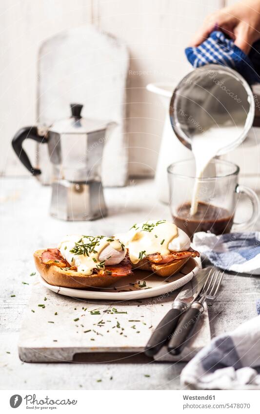 Traditional egg benedict with slices of bacon on toast, poached egg and hollandaise Poached Egg Poached Eggs pouring woman females women Toast toast bread