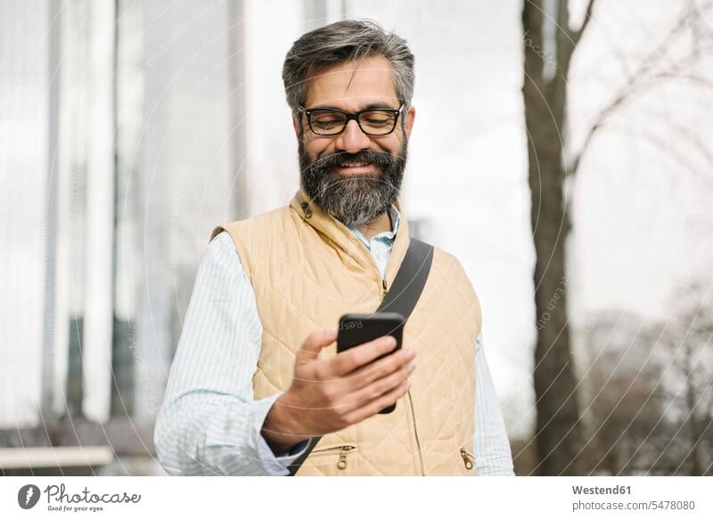 Smiling man using smartphone in the city, Frankfurt, Germany business life business world business person businesspeople Business man Business men Businessmen