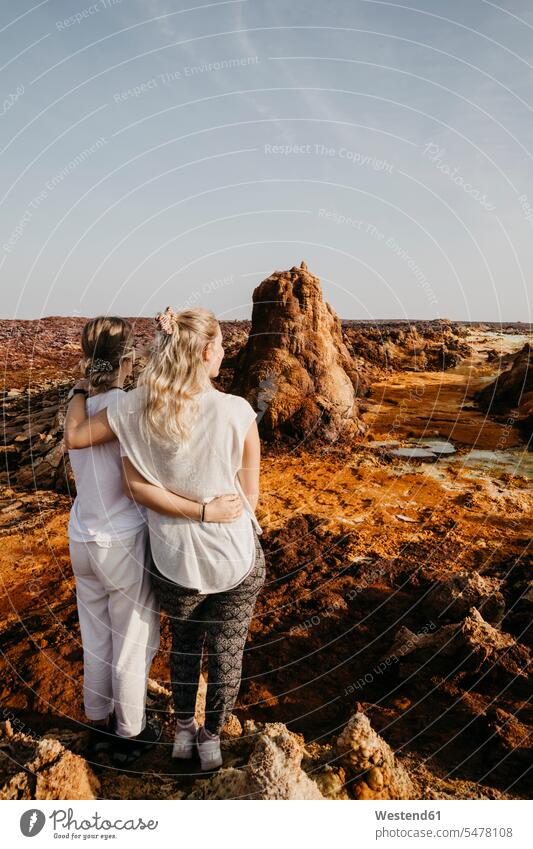Rear view of female friends looking at volcanic landscape in Dallol Geothermal Area, Danakil Depression, Ethiopia, Afar outdoors location shots outdoor shot