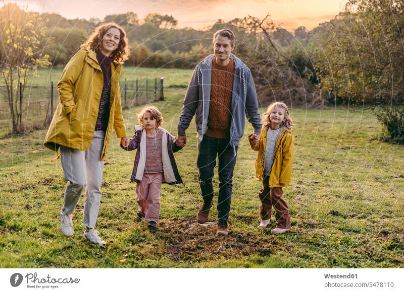 Portrait of happy family with two daughters walking on a meadow in autumn human human being human beings humans person persons caucasian appearance