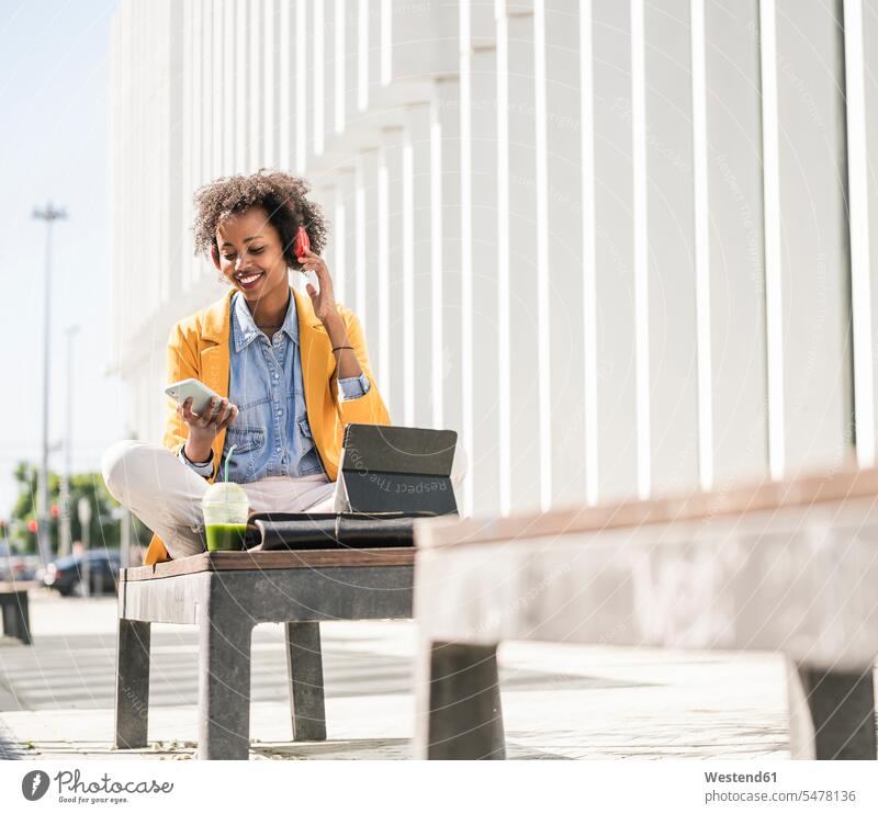 Smiling young woman with headphones, smartphone and tablet in the city human human being human beings humans person persons 1 one person only only one person