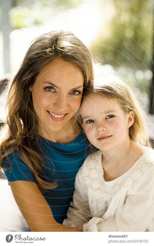 Portrait of smiling mother with daughter in front of window mommy mothers ma mummy mama windows portrait portraits daughters home at home parents family