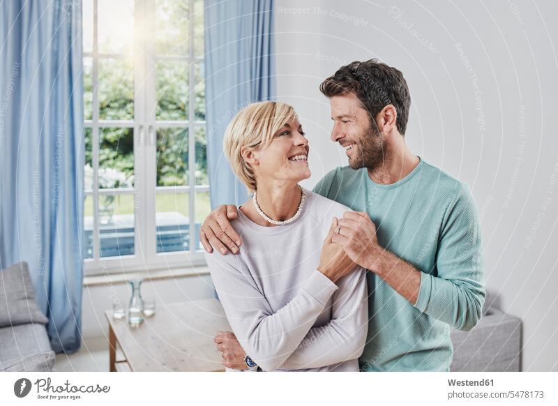 Portrait of happy couple embracing at home portrait portraits happiness embrace Embracement hug hugging twosomes partnership couples people persons human being