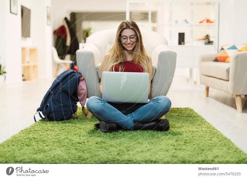 Casual young woman using laptop in coworking space office offices office room office rooms smiling smile Laptop Computers laptops notebook females women